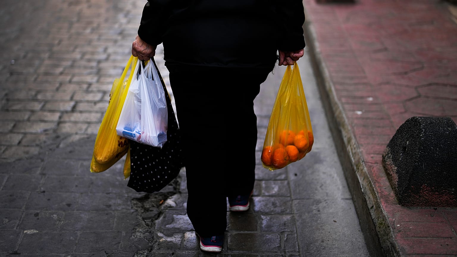 Kobieta niesie torby pełne jedzenia po zakupach w Stambule, 7 lutego 2024 r.