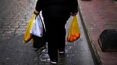 Eine Frau trägt Taschen voller Lebensmittel nach einem Einkauf in Istanbul, 7. Februar 2024.
