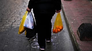 Eine Frau trägt Taschen voller Lebensmittel nach einem Einkauf in Istanbul, 7. Februar 2024.