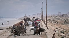 نازحون فلسطينيون يحملون أمتعتهم على مشارف مدينة غزة، الجمعة 21 مارس/آذار 2025. 