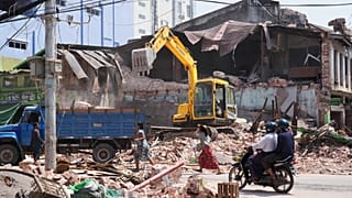 Anwohner fahren auf Motorrädern, während Rettungskräfte nach dem Erdbeben vom Freitag in Naypyidaw Trümmer von beschädigten Gebäuden entfernen, 2. April 2025
