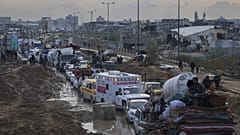 Displaced Palestinians wait at a security checkpoint in the Netzarim Corridor while traveling to the north of Gaza, 11 February, 2025