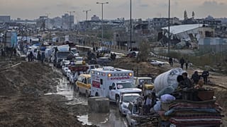 Displaced Palestinians wait at a security checkpoint in the Netzarim Corridor while traveling to the north of Gaza, 11 February, 2025