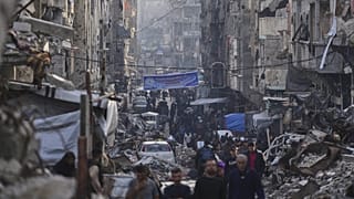 Palestinianos caminham pelo campo de Al-Shati na cidade de Gaza, 25 de março de 2025