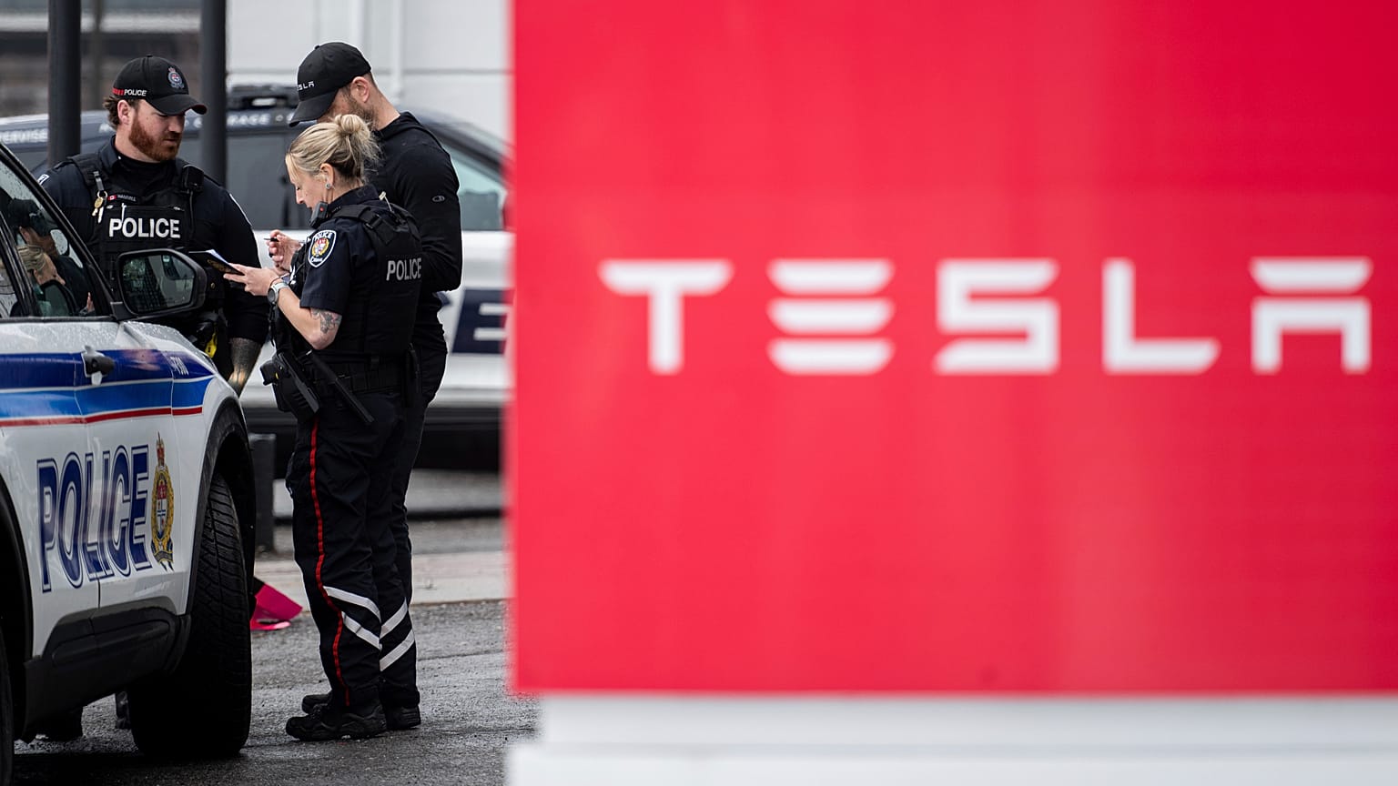 Ottawa Polis Teşkilatı (OPS) görevlileri, 31 Mart 2025 Pazartesi günü Ottawa'da pembe sprey boya ile hasar gören Tesla Servis ve Showroom merkezinde görülüyor.