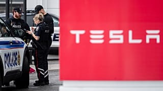 Agentes do Serviço de Polícia de Ottawa (OPS) são vistos num centro de assistência e num showroom da Tesla depois de este ter sido danificado com tinta spray cor-de-rosa em Ottawa, na segunda-feira, 31 de março de 2025.