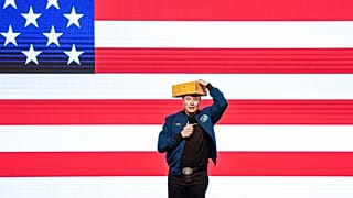 Elon Musk indossa una testa di formaggio durante un'assemblea cittadina domenica 30 marzo 2025 a Green Bay, Wis.