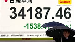 İnsanlar 3 Nisan 2025 Perşembe günü Tokyo'da bir menkul kıymetler firmasında Japonya'nın Nikkei 225 endeksinin günün erken saatlerindeki kaybını gösteren elektronik bir hisse senedi panosunun önünden geçiyor.