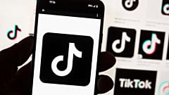FILE - The TikTok logo is displayed n a mobile phone in front of a computer screen displaying the TikTok home screen, Oct. 14, 2022, in Boston. 