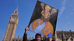 Ressam Kaya Mar, 3 Nisan 2025 Perşembe günü Londra'daki Westminster'da ABD Başkanı Donald Trump'ın tablosuyla poz veriyor.