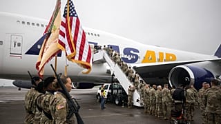 Um grupo de soldados do 87º Batalhão de Apoio à Manutenção da Divisão do Exército dos EUA embarca num avião fretado durante a sua deslocação para a Europa, a 11 de março de 2022