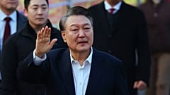 Yoon Suk Yeol, presidente da Coreia do Sul, acena aos seus apoiantes à saída de um centro de detenção em Uiwang, Coreia do Sul, no sábado, 8 de março de 2025.
