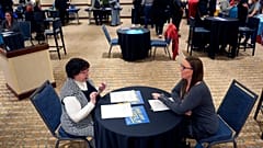 Fired IRS worker Brittany Glenn, right, talks to recruiter Lena Lager during a jobs fair for laid-off federal workers Saturday, March 15, 2025, in Kansas City, Mo. 