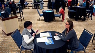 İşten çıkarılan IRS çalışanı Brittany Glenn, sağda, 15 Mart 2025 Cumartesi günü Kansas City, Mo'da işten çıkarılan federal çalışanlar için düzenlenen bir iş fuarı sırasında işe alım görevlisi Lena Lager ile görüşüyor. 