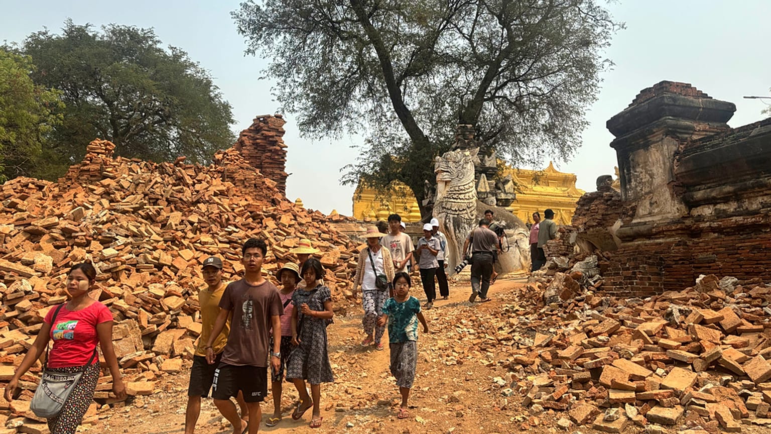 Los visitantes caminan cerca de la entrada del Monasterio Maha Aungmye Bonzan, conocido como el Monasterio de Ladrillos Me Nu, tras el terremoto del viernes en Myanmar
