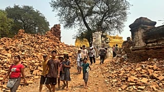 Los visitantes caminan cerca de la entrada del Monasterio Maha Aungmye Bonzan, conocido como el Monasterio de Ladrillos Me Nu, tras el terremoto del viernes en Myanmar