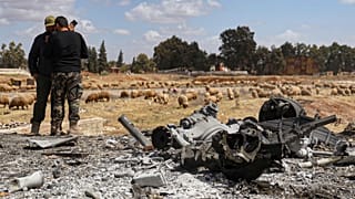  عنصران في الجيش السوري يتفقدان موقع غارة إسرائيلية على قاعدة جوية عسكرية بالقرب من حماة ، سوريا ، الخميس 3 أبريل 2025