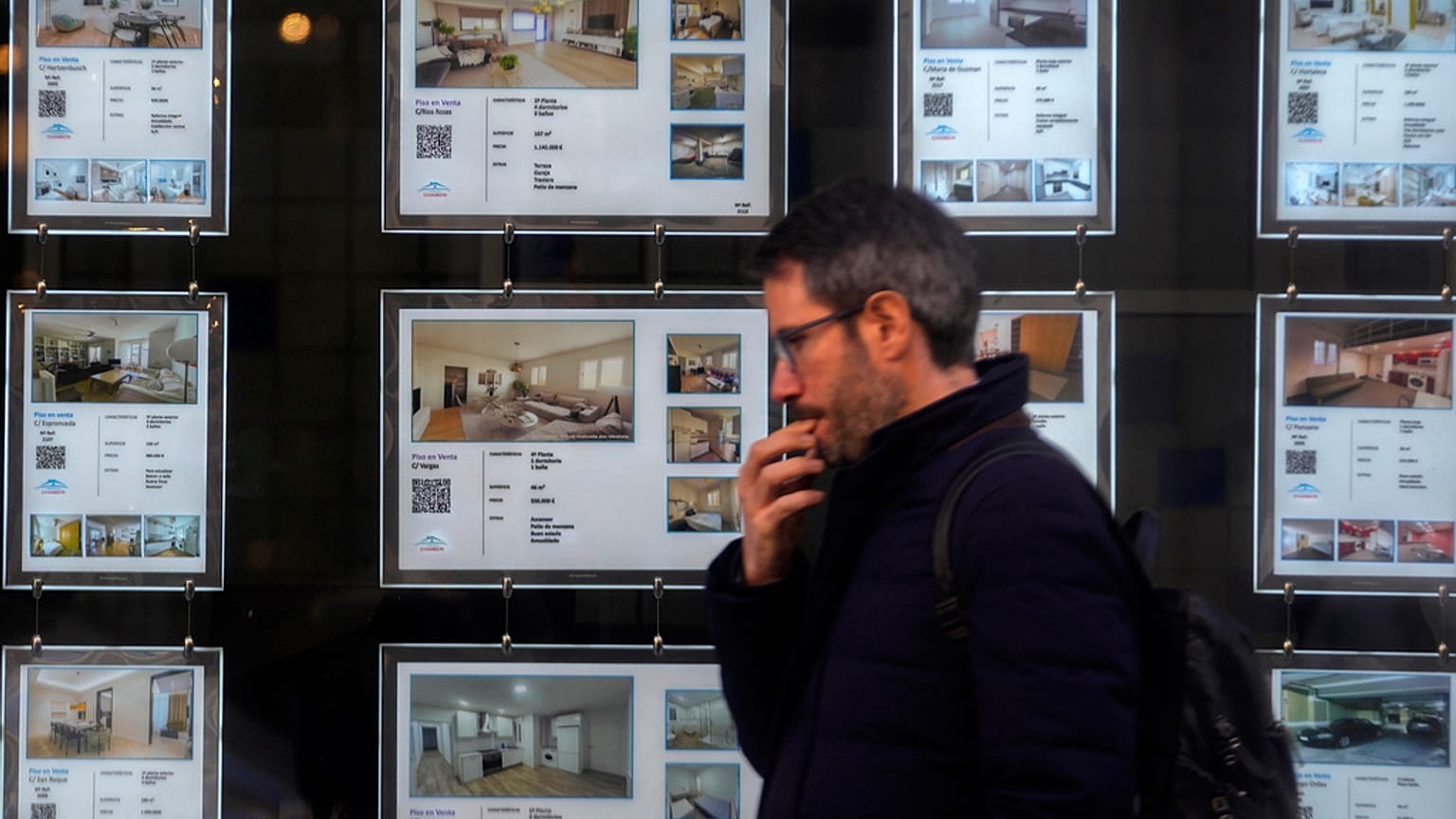 Ένας άνδρας περπατά μπροστά από ένα μεσιτικό γραφείο που διαφημίζει διαμερίσματα στη Μαδρίτη, Ισπανία, την Τρίτη 14 Ιανουαρίου 2025.