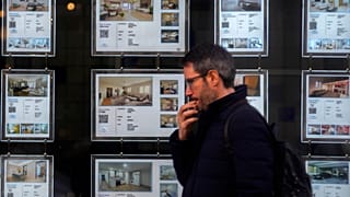 Un hombre pasa por delante de una agencia inmobiliaria que anuncia pisos en Madrid, España, el martes 14 de enero de 2025.