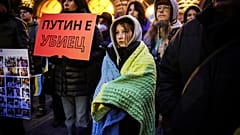 Bulgaristan'da düzenlenen bir protestoda bir kadın, "Putin katil" yazılı bir döviz tutuyor.