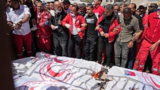 Mourners gather around the bodies of eight Red Crescent emergency responders killed in an Israeli attack a week earlier, recovered in the Gaza Strip on Monday 31 March 2025.