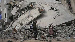 Um homem passa por uma casa destruída por um ataque do exército israelita em Khan Younis, no sul da Faixa de Gaza, no domingo, 6 de abril de 2025