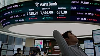 Валютный трейдер реагирует на экран, показывающий Korea Composite Stock Price Index (KOSPI)