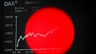 A red light of a TV camera is seen in front of the display board with the DAX stock index in the trading hall of the Frankfurt Stock Exchange, 7 April, 2025
