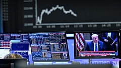 Hinter einem Fernsehbildschirm mit US-Präsident Donald Trump zeigt die Anzeigetafel mit der Dax-Kurve fallende Aktienkurse, in Frankfurt, Deutschland. 3. April 2025.