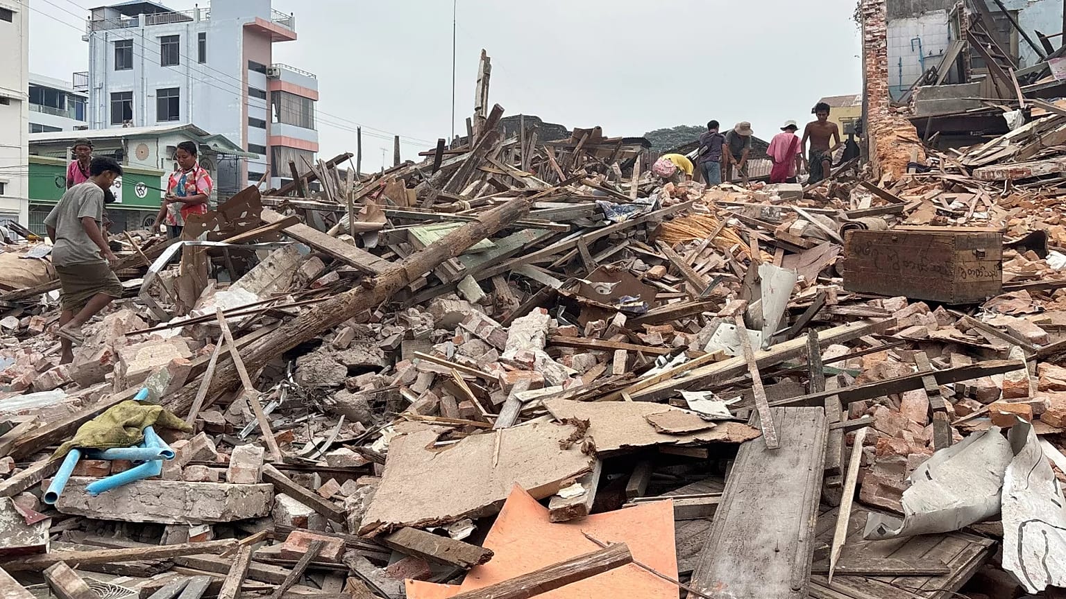 Des personnes nettoient les débris des bâtiments endommagés, le 28 mars, à Naypyitaw.