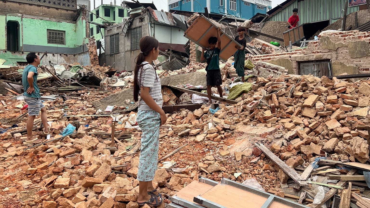 People clean debris from damaged buildings in the aftermath of an earthquake in Naypyidaw, 7 April, 2025