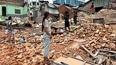 People clean debris from damaged buildings in the aftermath of an earthquake in Naypyidaw, 7 April, 2025