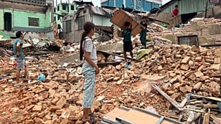 People clean debris from damaged buildings in the aftermath of an earthquake in Naypyidaw, 7 April, 2025