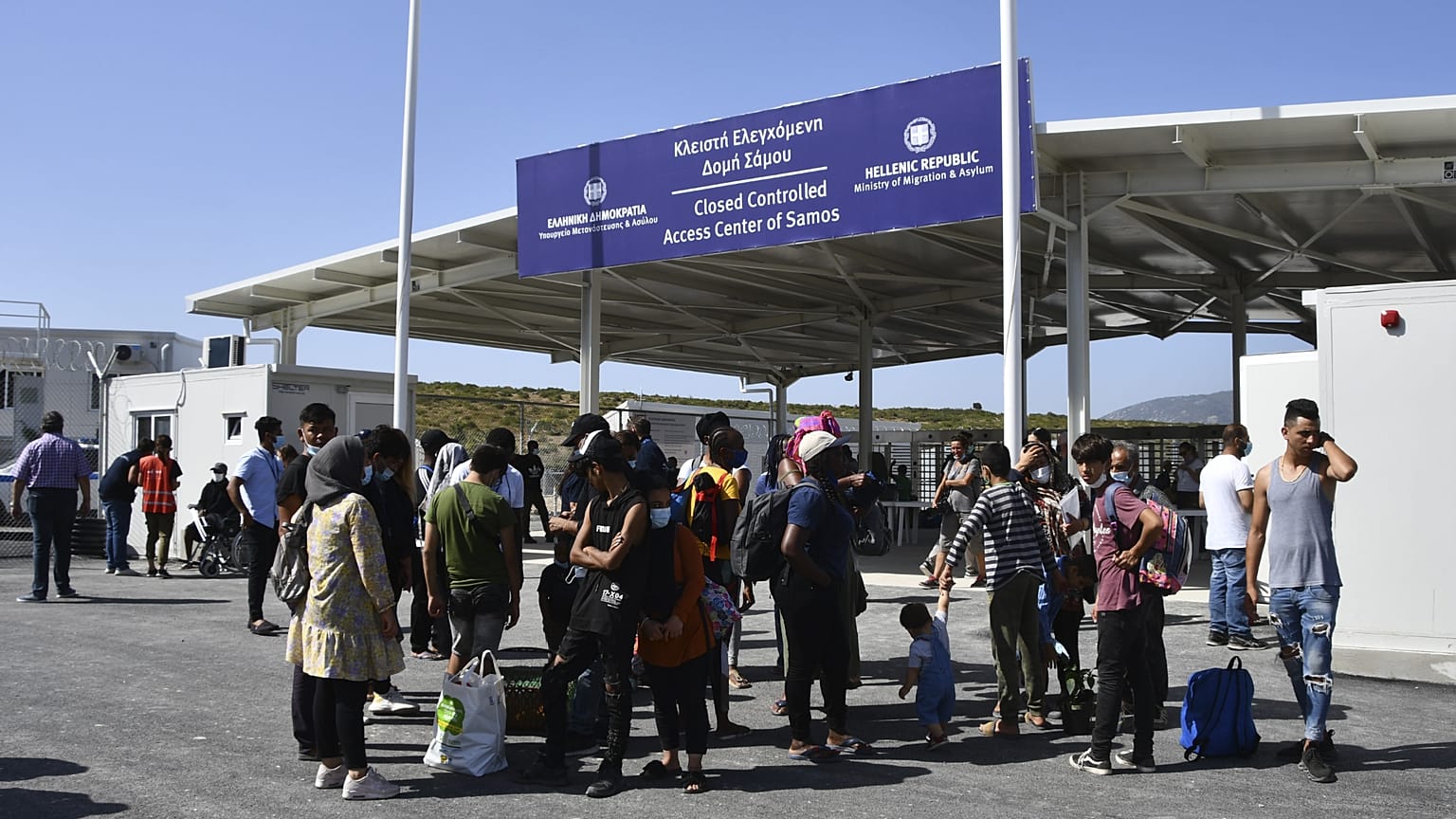 Göçmenler, Yunanistan'ın Samos adasındaki Zervou köyünde bulunan tesisin önünde beklerken, 20 Eylül 2021