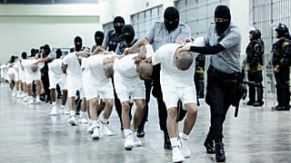 Börtönőrök szállítják az Egyesült Államokból kitoloncolt venezuelai bandatagokat az El Salvador-beli fogolytáborba