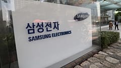 People walk near the logo of the Samsung Electronics Co. at its office in Seoul, South Korea, Thursday, Oct. 31, 2019. 