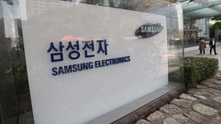 People walk near the logo of the Samsung Electronics Co. at its office in Seoul, South Korea, Thursday, Oct. 31, 2019. 