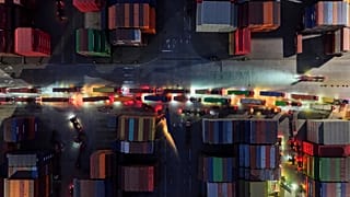 Camiões em fila para partir de um terminal de contentores em Nanjing, na província de Jiangsu, no leste da China, na terça-feira, 8 de abril de 2025.