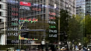 An electronic board displays Shanghai shares trading index in Beijing's Central Business District, 9 April 2025