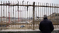 Ein stiller Beobachter vor der Baustelle des Olympischen Dorfes in Mailand, März 2023