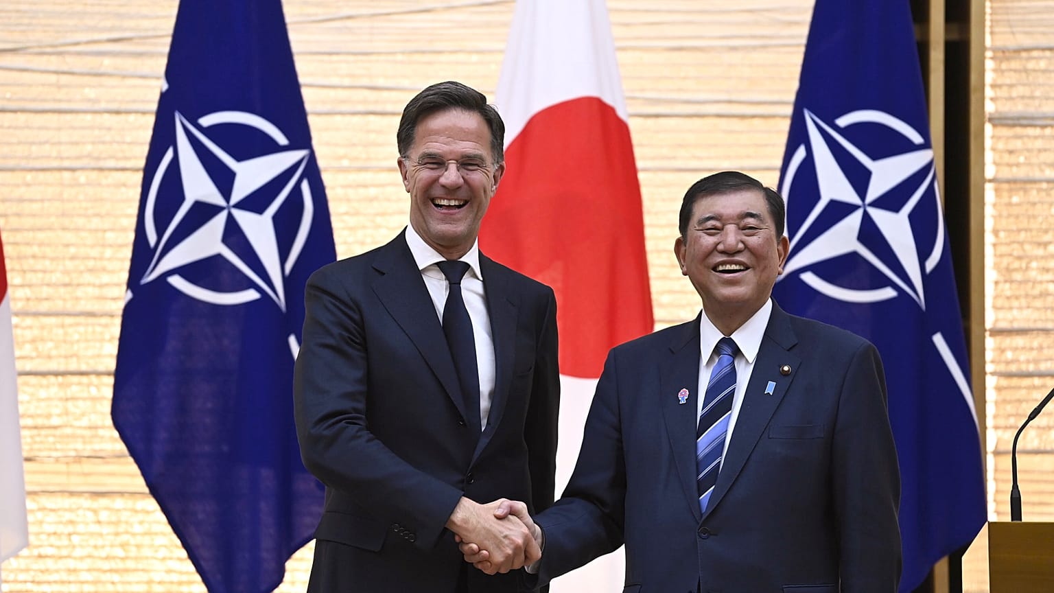 O primeiro-ministro japonês Ishiba Shigeru e o secretário-geral da NATO, Mark Rutte, apertam as mãos em Tóquio, 9 de abril de 2025 
