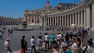 Tourists and faithful wander in St. Peter's Square at the Vatican.