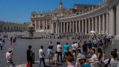 Tourists and faithful wander in St. Peter's Square at the Vatican. 