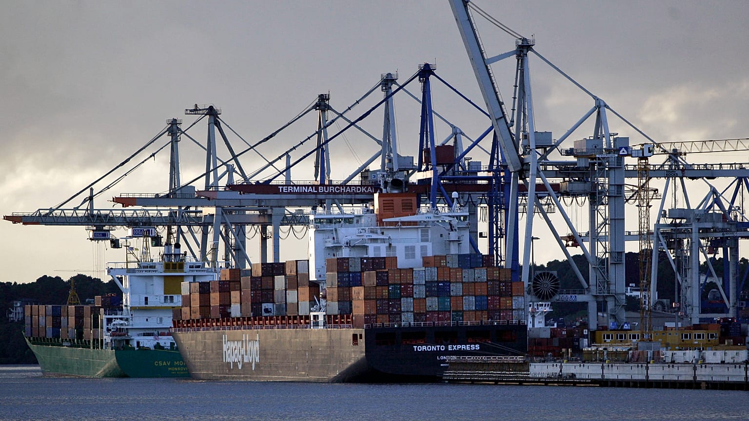 Statek towarowy załadowany kontenerami opuszcza terminal cargo.