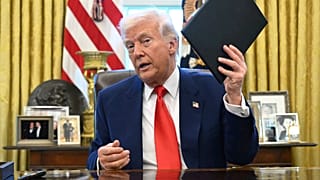 Prezydent Donald Trump trzyma rozporządzenie wykonawcze w Gabinecie Owalnym Białego Domu w środę 9 kwietnia 2025 r. w Waszyngtonie.