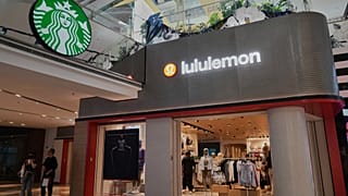 Compradores passam por um café Starbuck e uma loja Lululemon num centro comercial, em Pequim, China. 10 de abril de 2025.