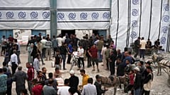 فلسطينيون ينتظرون الحصول على أكياس الدقيق وغيرها من المساعدات الإنسانية التي توزعها الأونروا في جباليا، قطاع غزة، يوم الثلاثاء 1 أبريل/نيسان 2025.