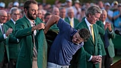 Scottie Scheffler puts the green Jacket on winner, Rory McIlroy, of Northern Ireland, at the Masters golf tournament, Sunday, April 13, 2025, in Augusta