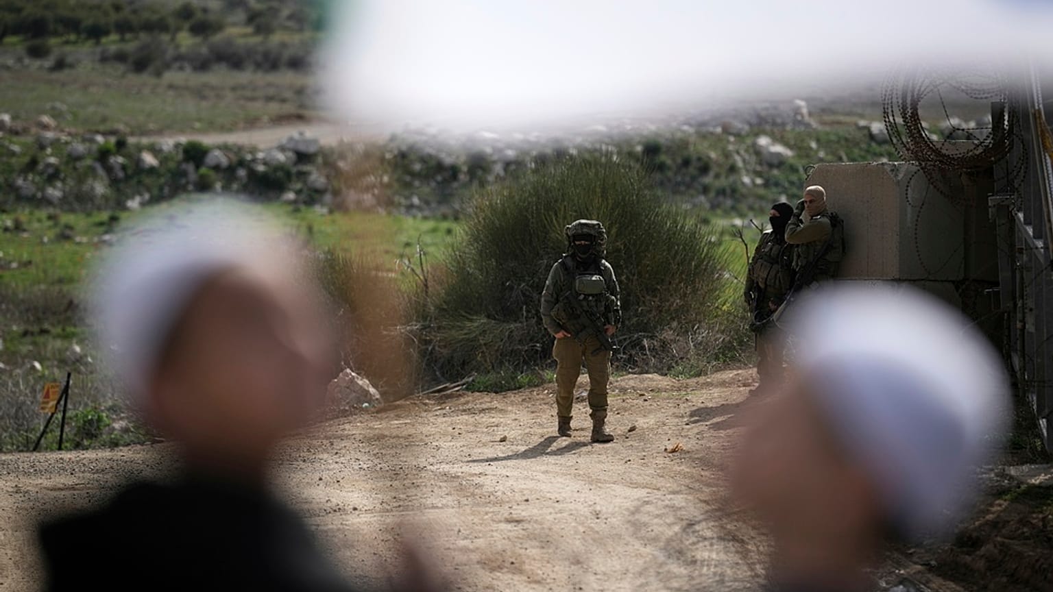 İsrail askerleri, Golan Tepeleri'ndeki Majdal Shams köyüne geçmek için Dürzileri taşıyan otobüsleri bekliyor.