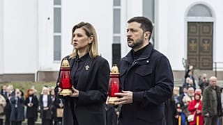 Prezydent Ukrainy Wołodymyr Zełenski i jego żona Ołena Zełenska niosą znicze ku czci ofiar rosyjskiej okupacji pod pomnikiem w Buczy, 31 marca 2025 r.